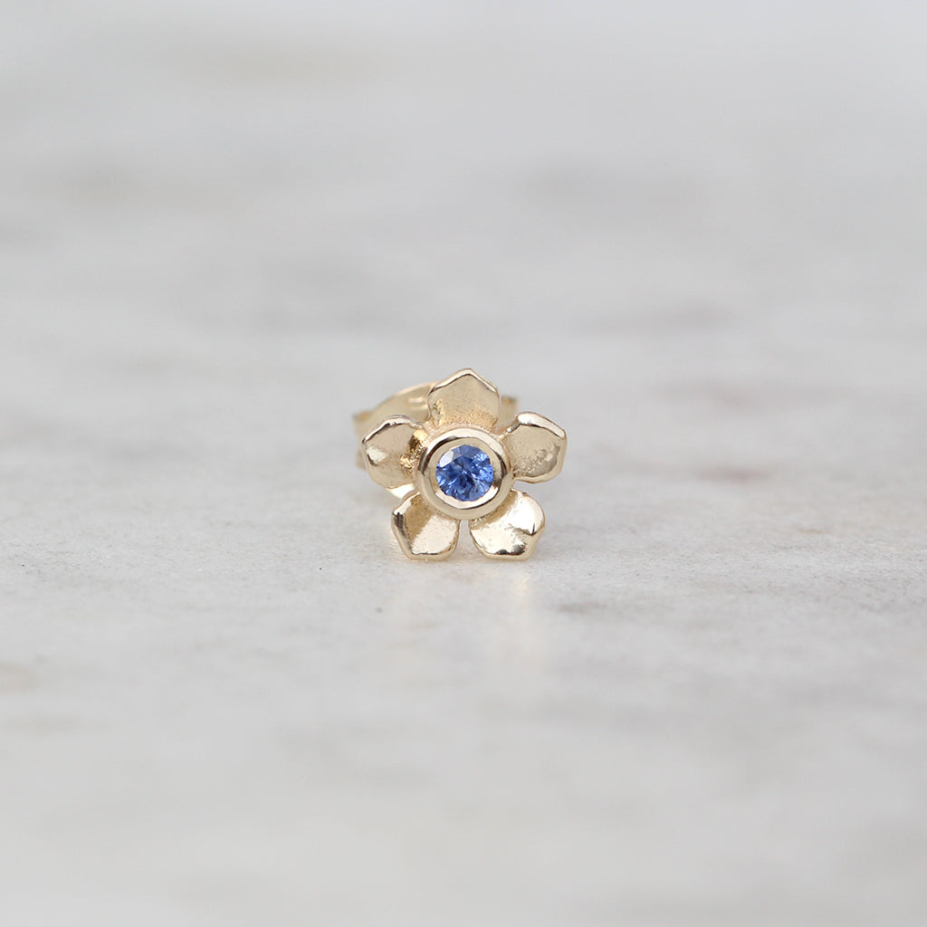 Gold forget me not flower stud with a Ceylon blue sapphire