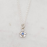 Silver forget me not flower necklace with a blue sapphire