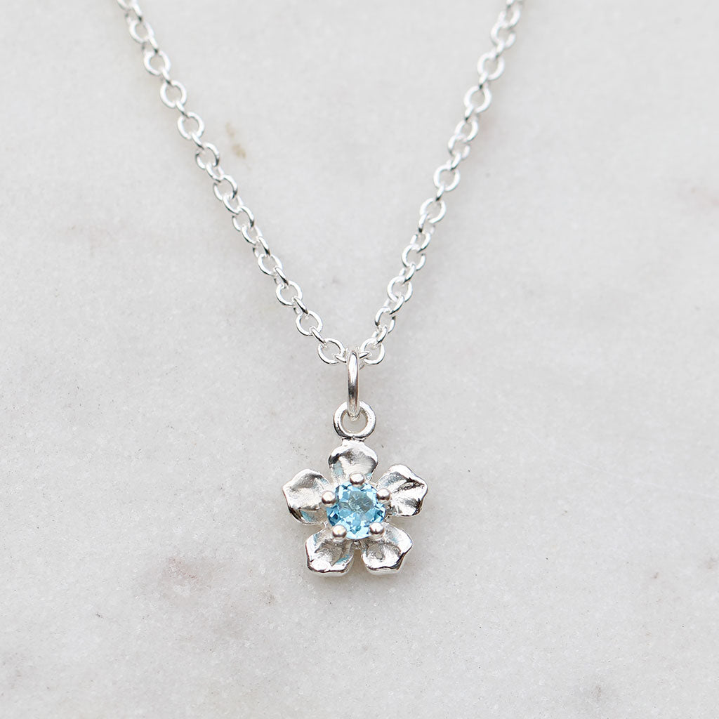 Forget me not flower necklace with a blue topaz