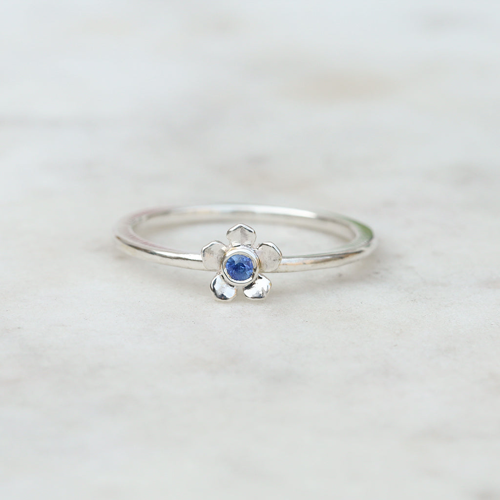 Silver forget me not flower ring with a blue sapphire