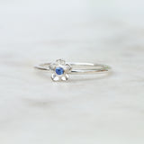Silver forget me not flower ring with a Ceylon blue sapphire