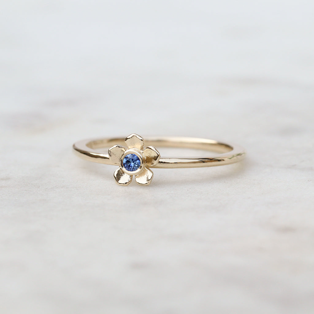 Gold forget me not flower ring with a Ceylon blue sapphire