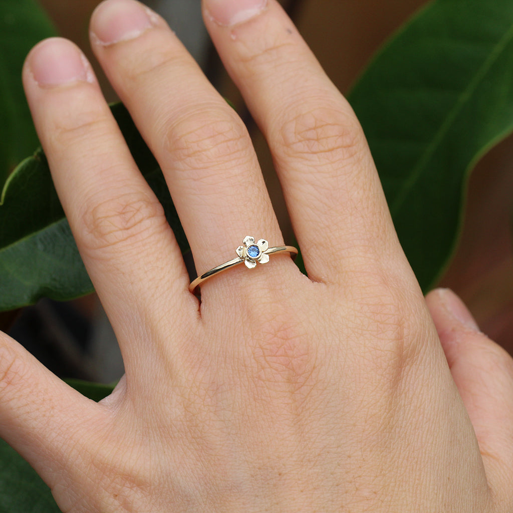 Gold forget me not flower ring with a blue sapphire