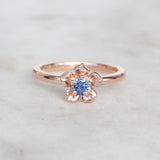 Rose gold forget me not flower ring with a sapphire