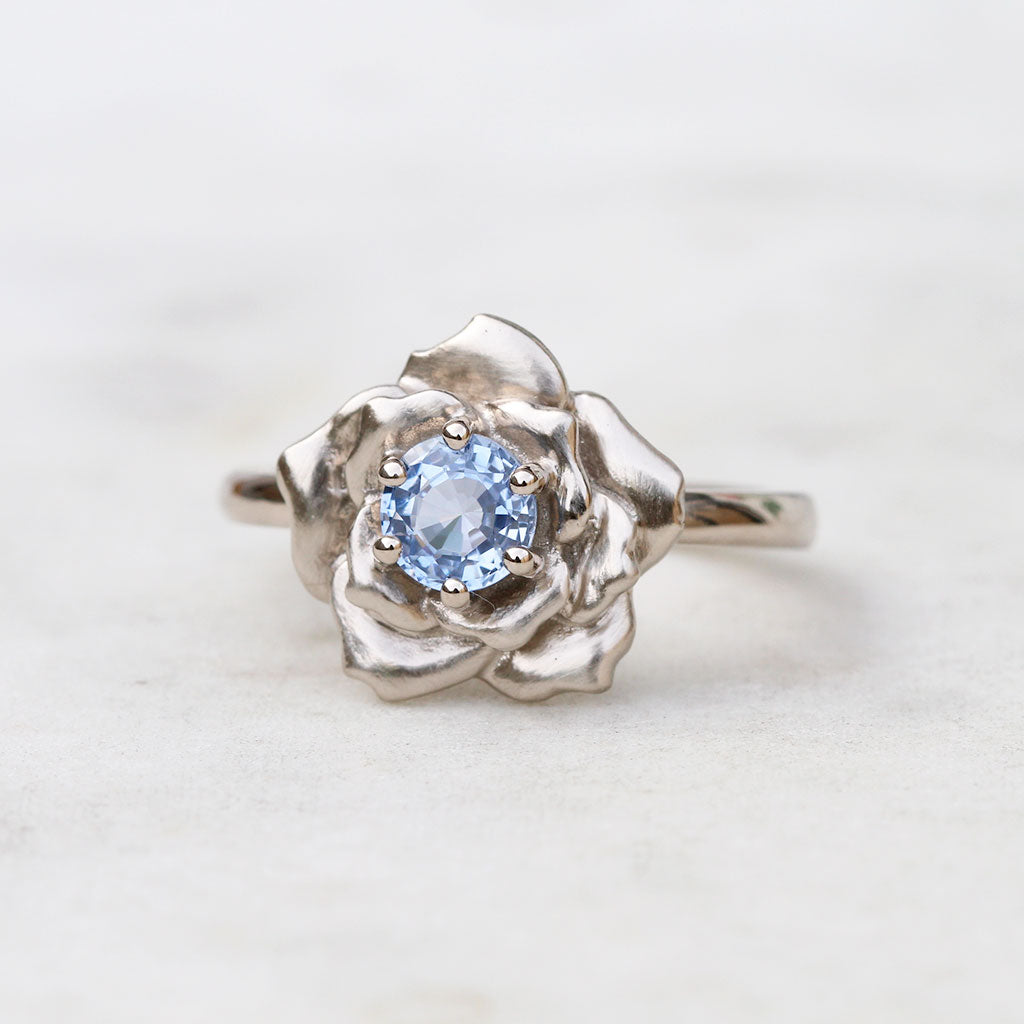 White gold rose engagement ring with a Ceylon sapphire