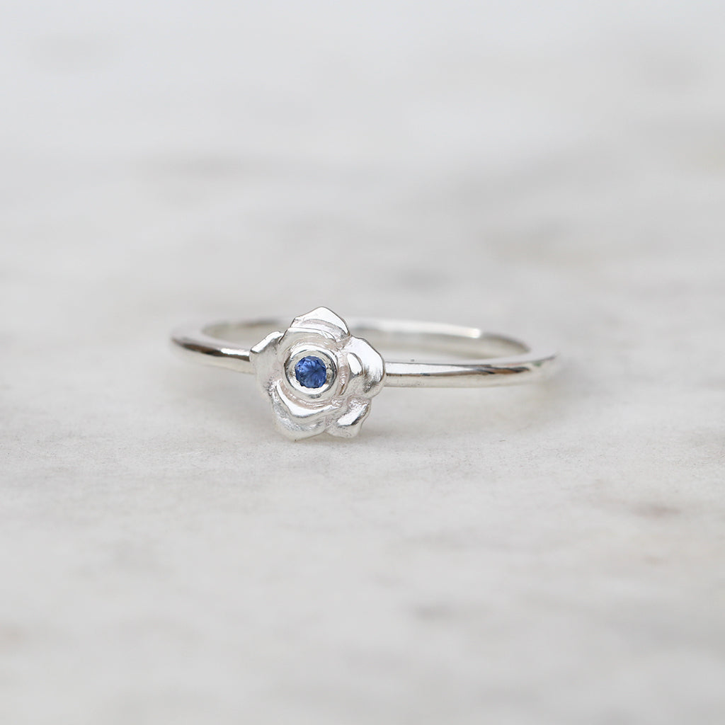 Silver rose ring with a blue sapphire