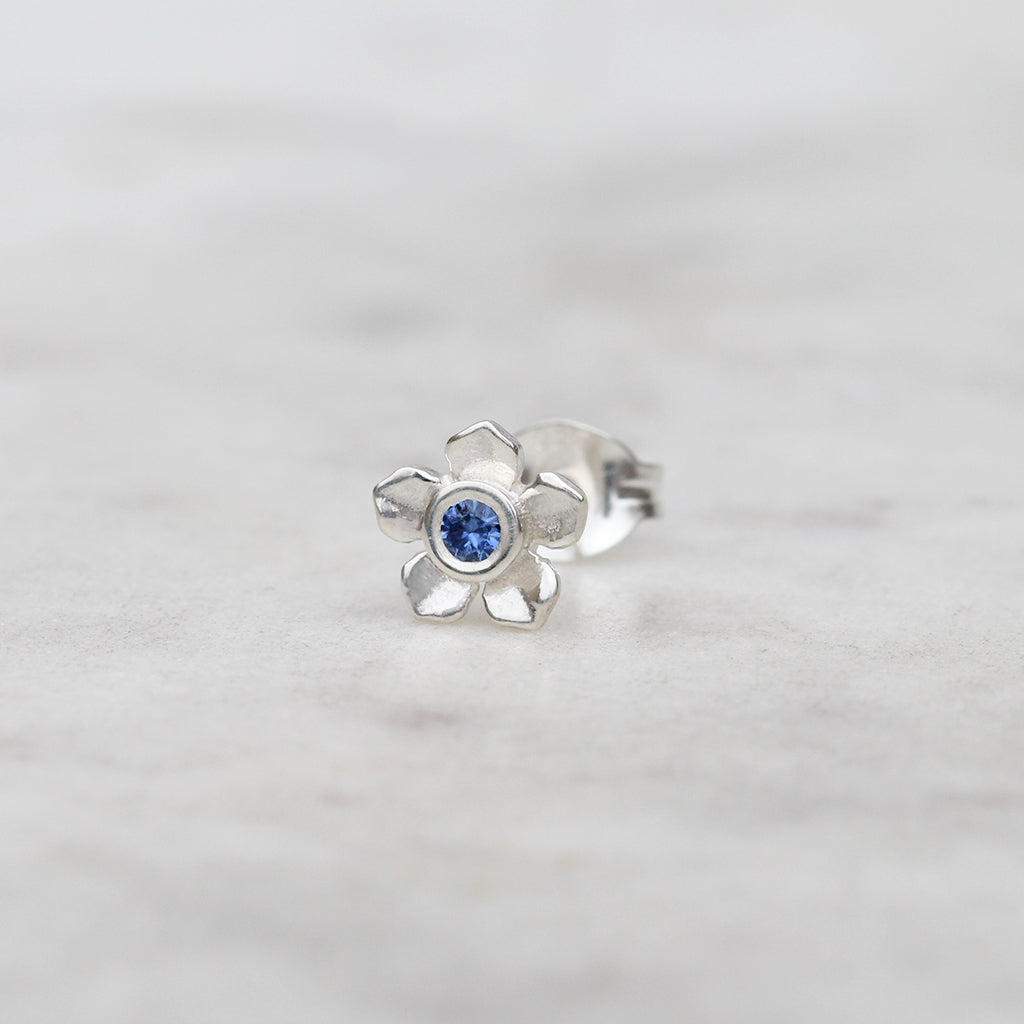 Silver forget me not flower stud with a blue sapphire