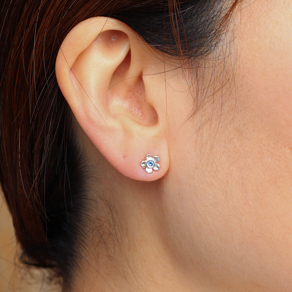 Silver forget me not flower stud with a blue sapphire