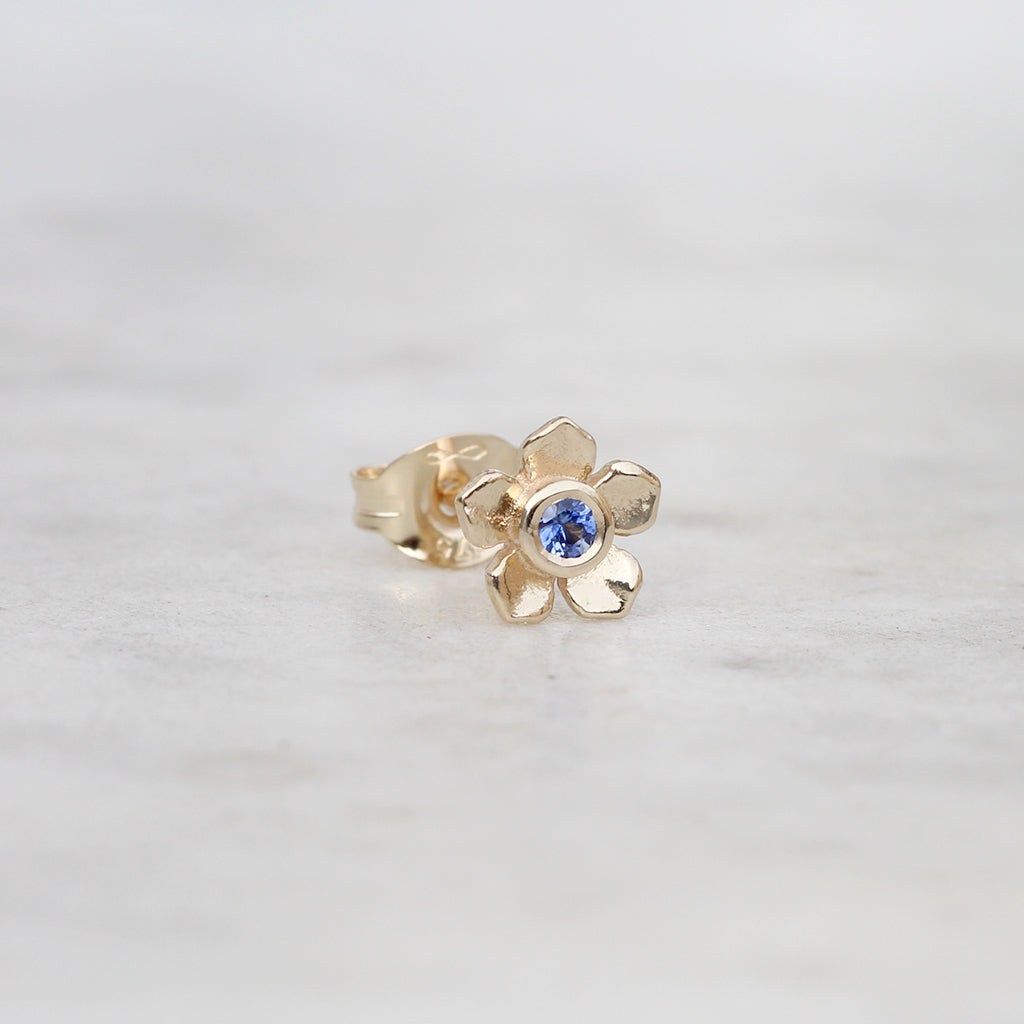 Gold forget me not flower stud with a blue sapphire