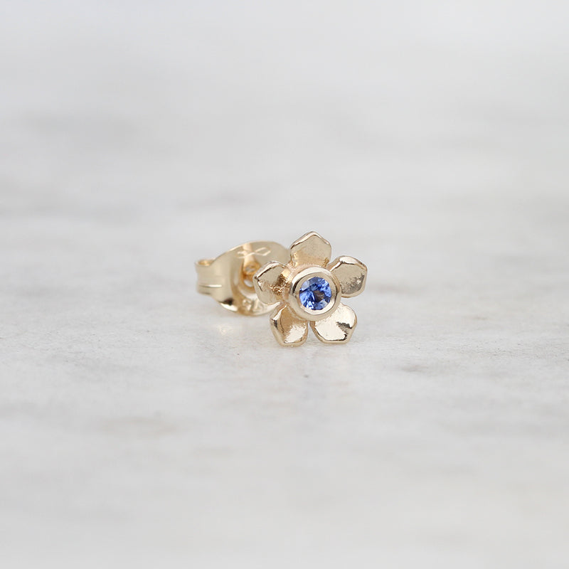 Gold forget me not flower stud with a blue sapphire