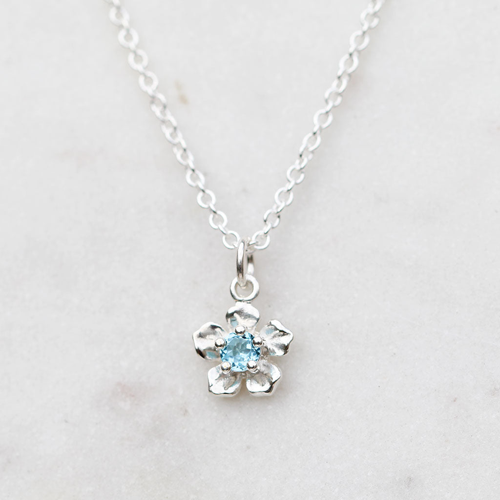 Silver forget me not necklace wth a blue topaz
