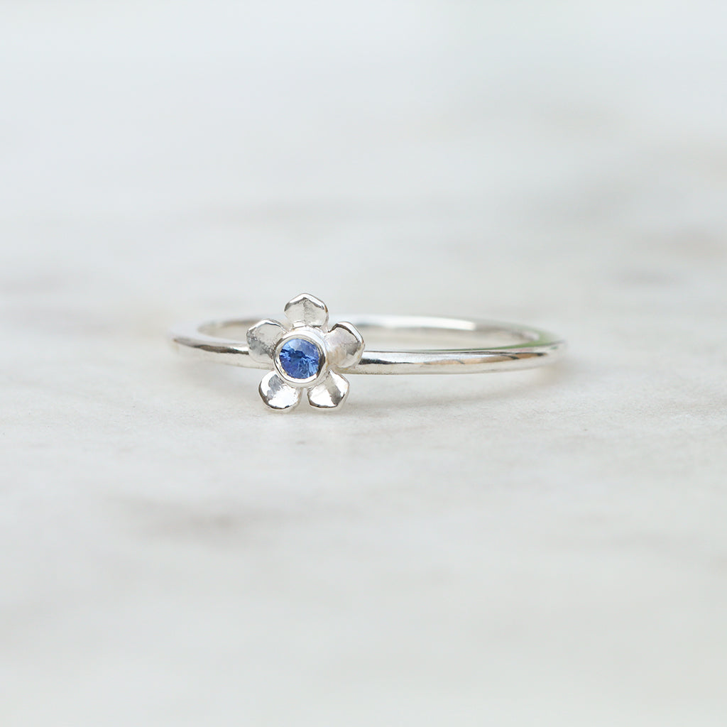 Silver forget me not flower ring with a Ceylon blue sapphire