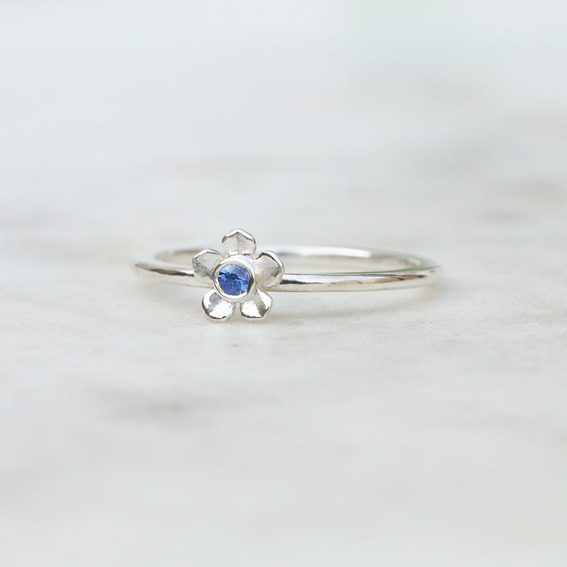 Silver forget me not flower ring with a Ceylon blue sapphire