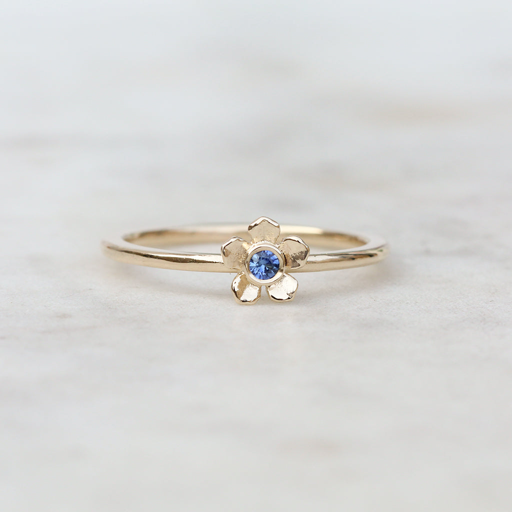 Gold forget me not flower ring with a blue sapphire