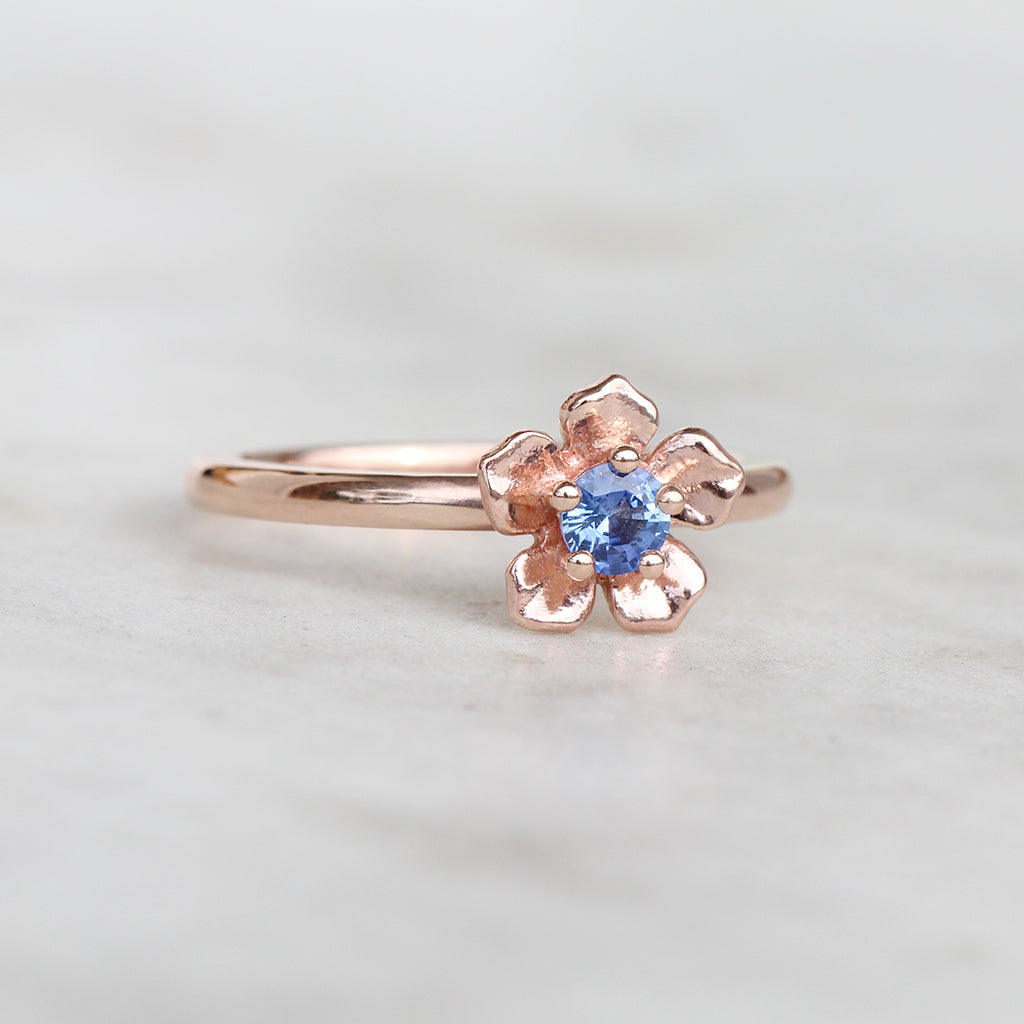 Rose gold forget me not flower ring with a Ceylon blue sapphire