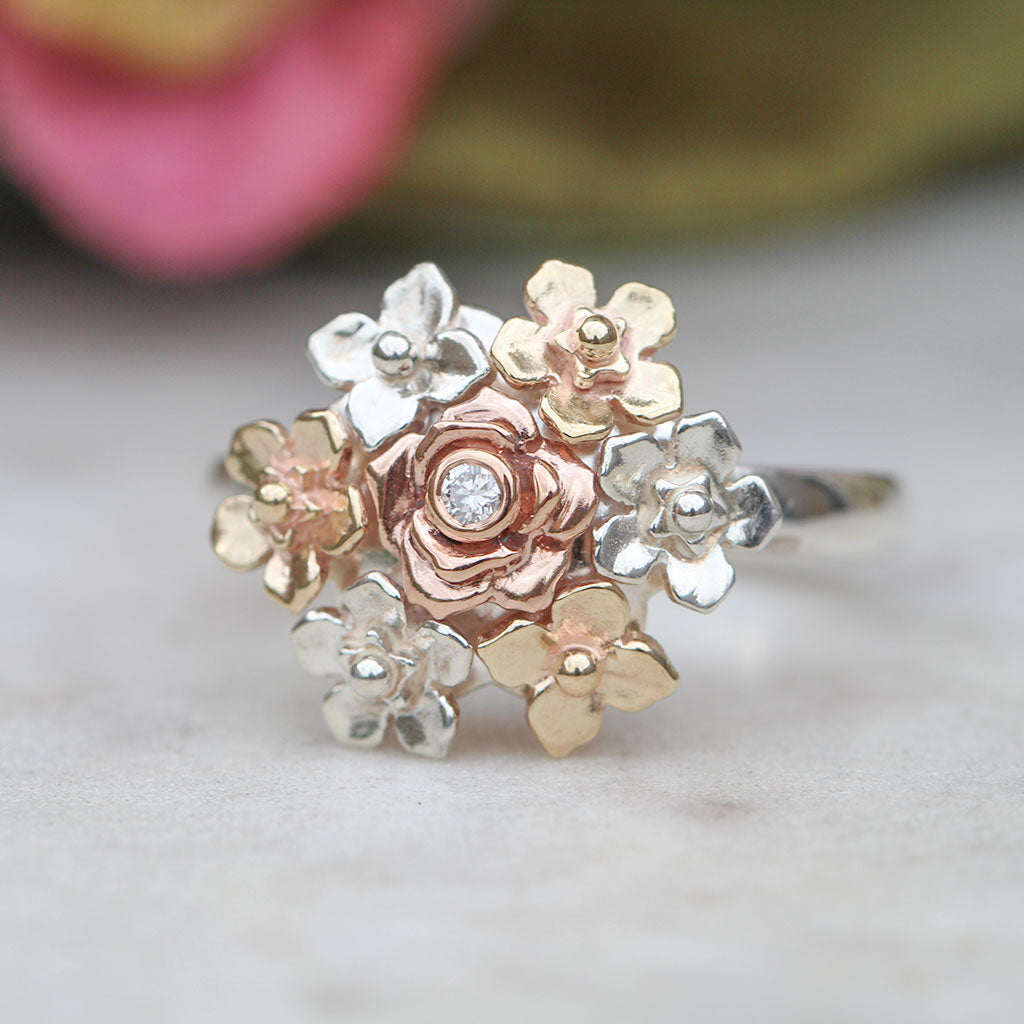 Posy ring in yellow gold, rose gold, and sterling silver with a diamond