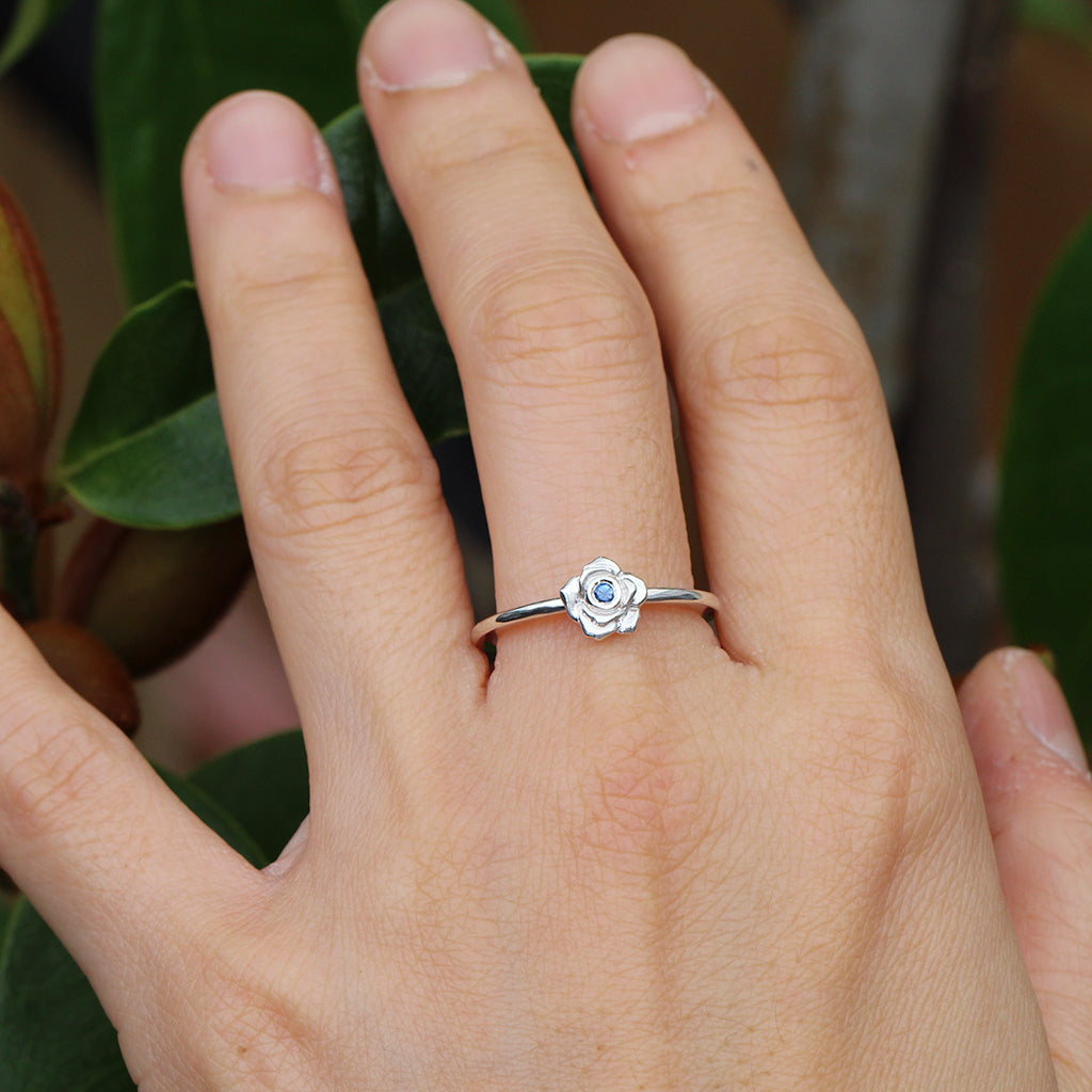 Silver rose ring with a blue sapphire