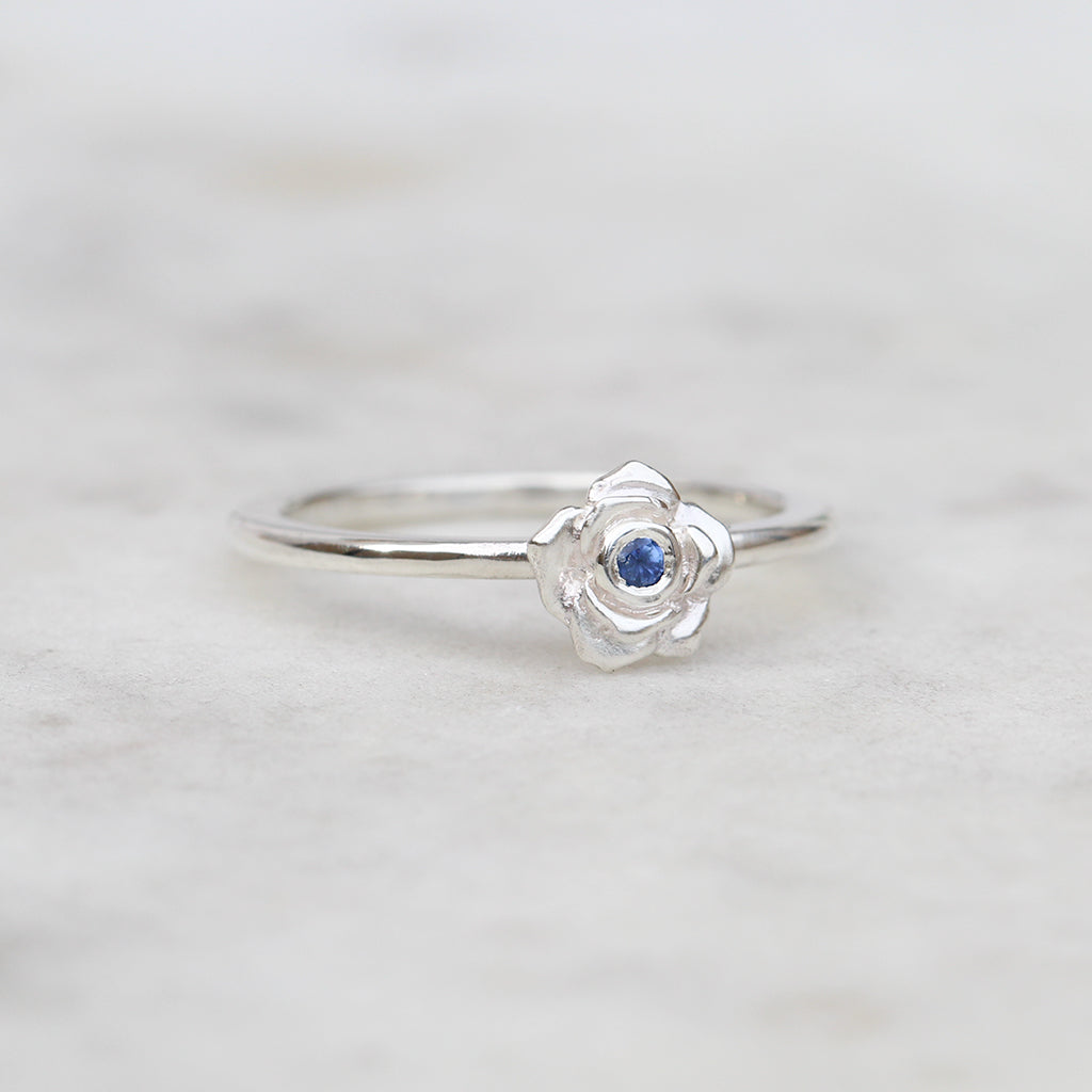 Silver rose ring with a blue sapphire